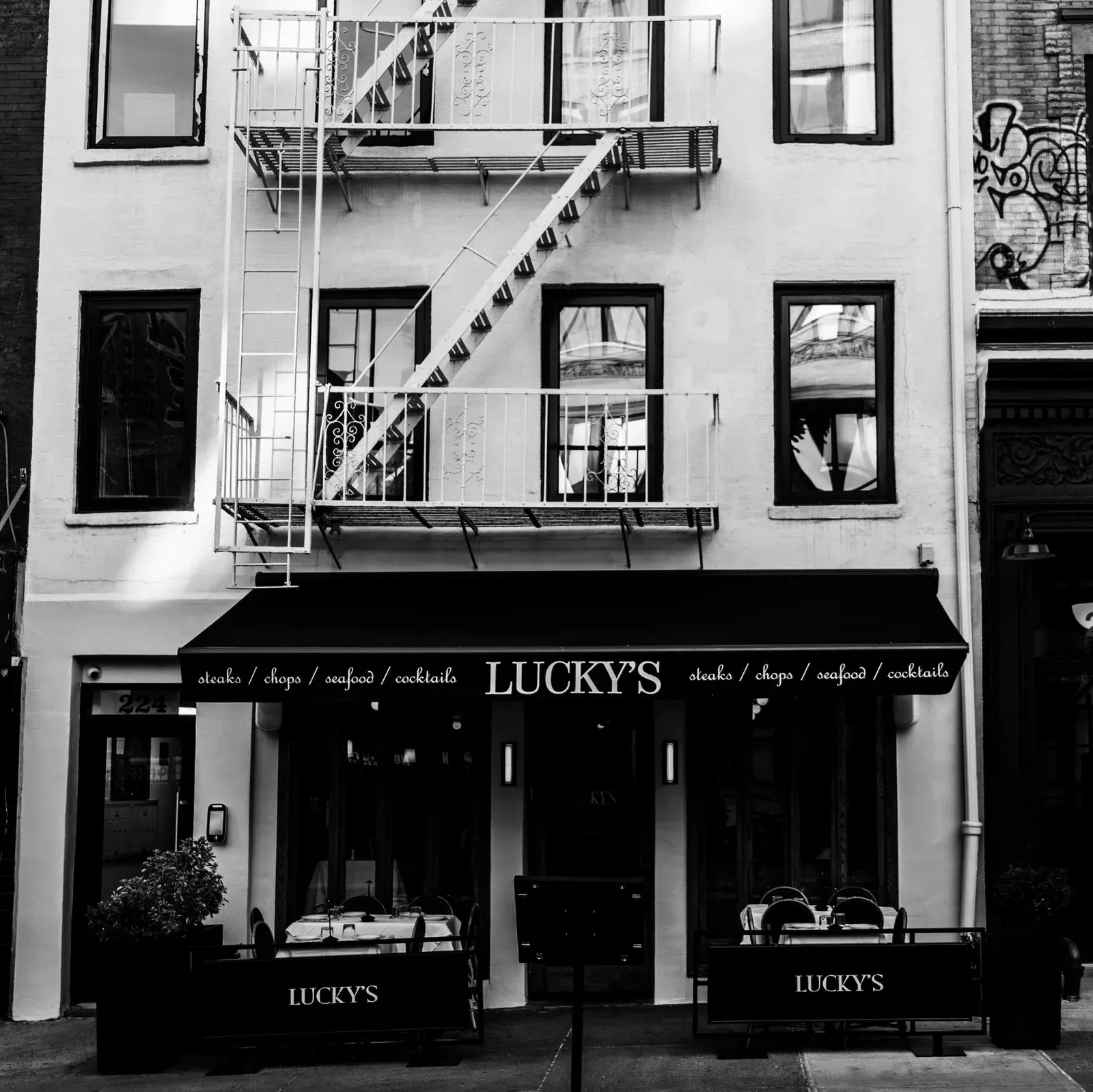 Exterior storefront of Lucky's Steakhouse SOHO on Lafayette Street featuring fire escape stairs